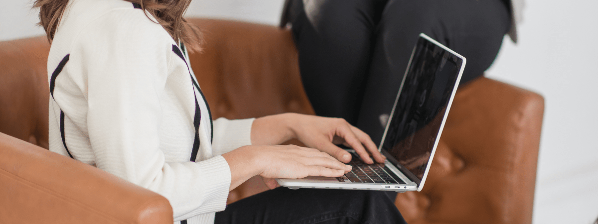 Woman working on laptop from home creating digital content and building brand awareness through online marketing